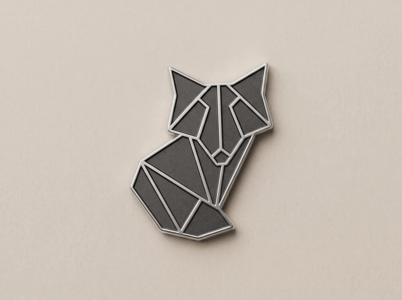 Silver metal piece cut in the shape of a geometric fox, with a dark fill