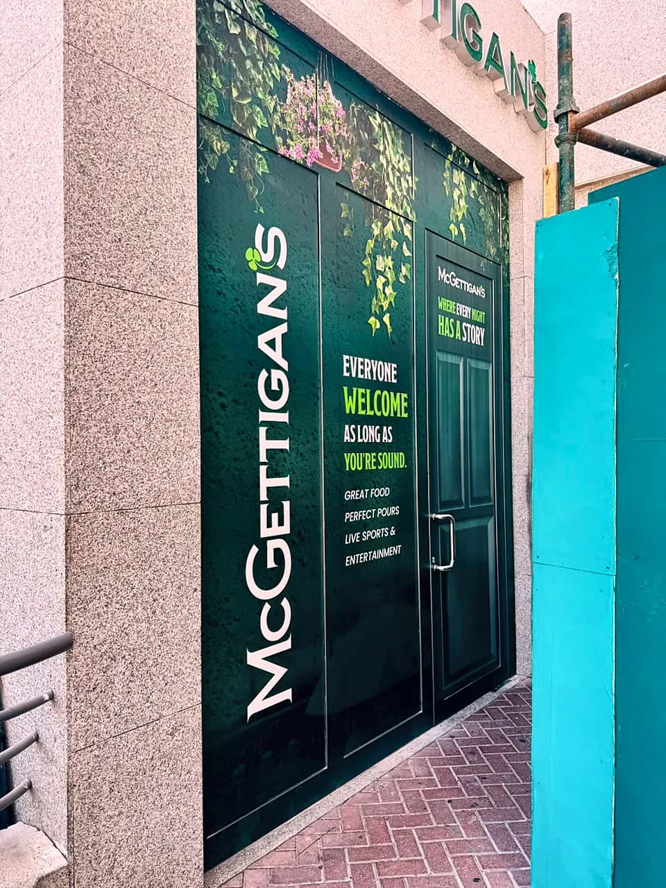 Double doors wrapped in dark green with McGettigan's running vertically and an Everyone welcome message