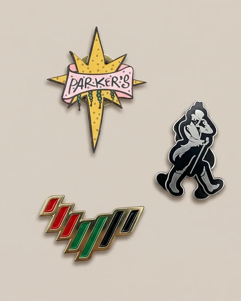 Custom pins made by Al Waha: a star-shaped Parker’s pin, a cut-out figure pin and a gold-edged enamel UAE flag pin