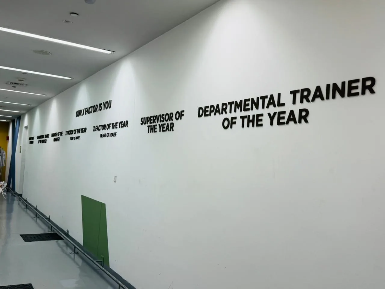 Long white wall with black 3D letters for staff awards including Supervisor of the Year and Departmental Trainer of the Year