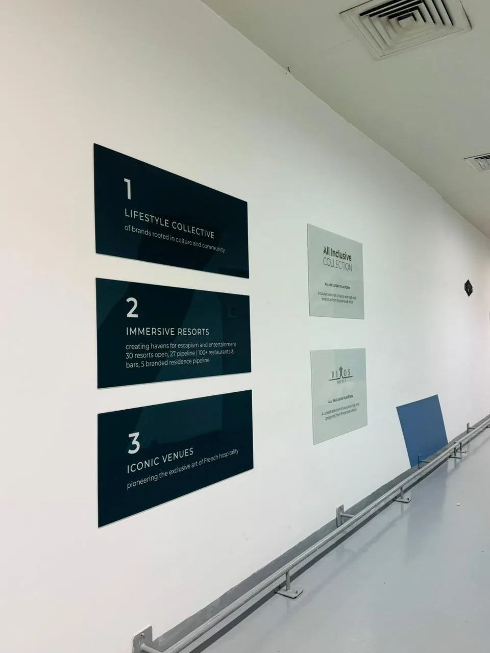Dark acrylic panels numbered 1 to 3 describing the lifestyle collective, immersive resorts and iconic venues, next to Rixos brand panels