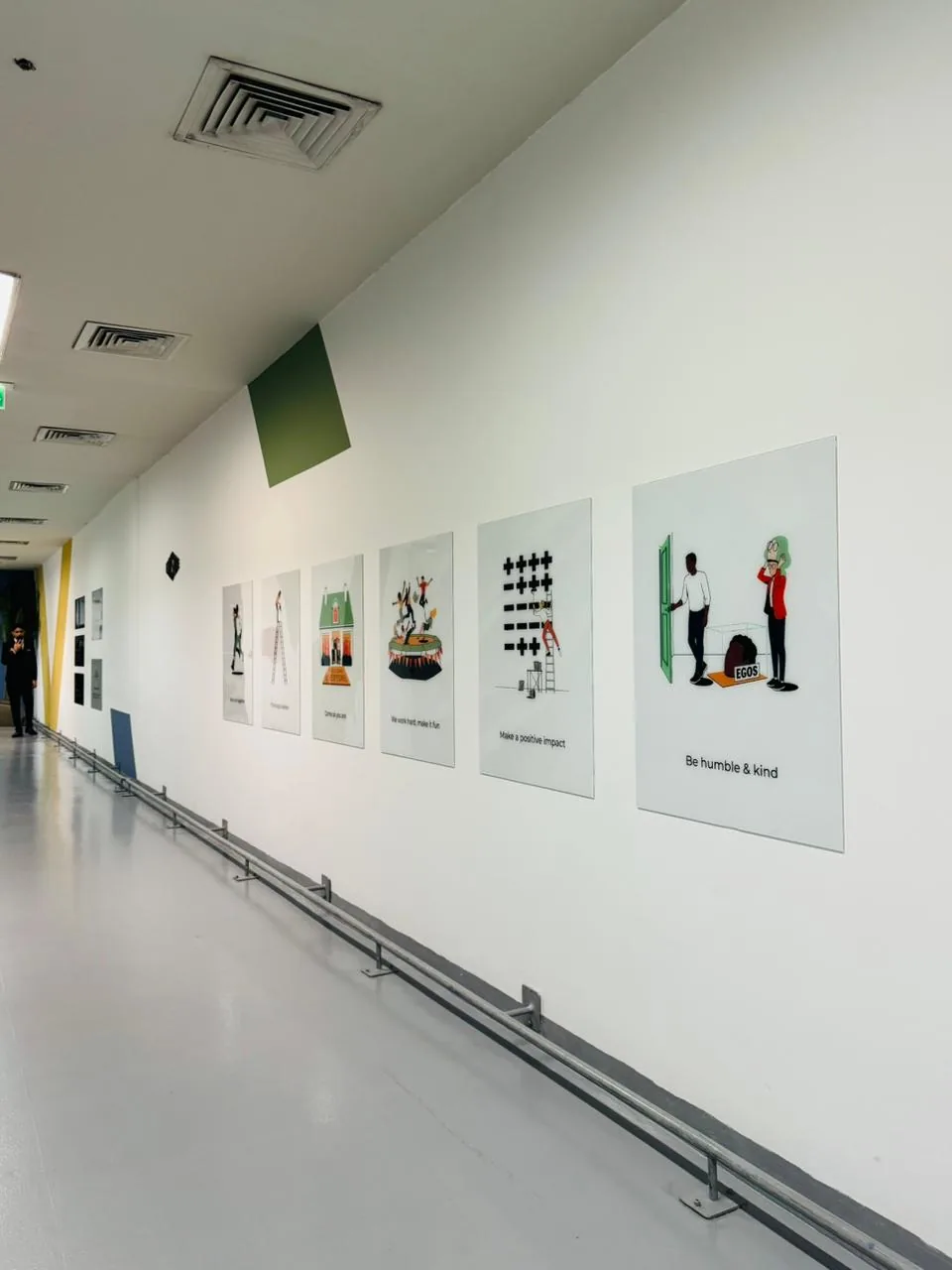 Row of illustrated acrylic panels with messages such as Be humble and kind and Make a positive impact