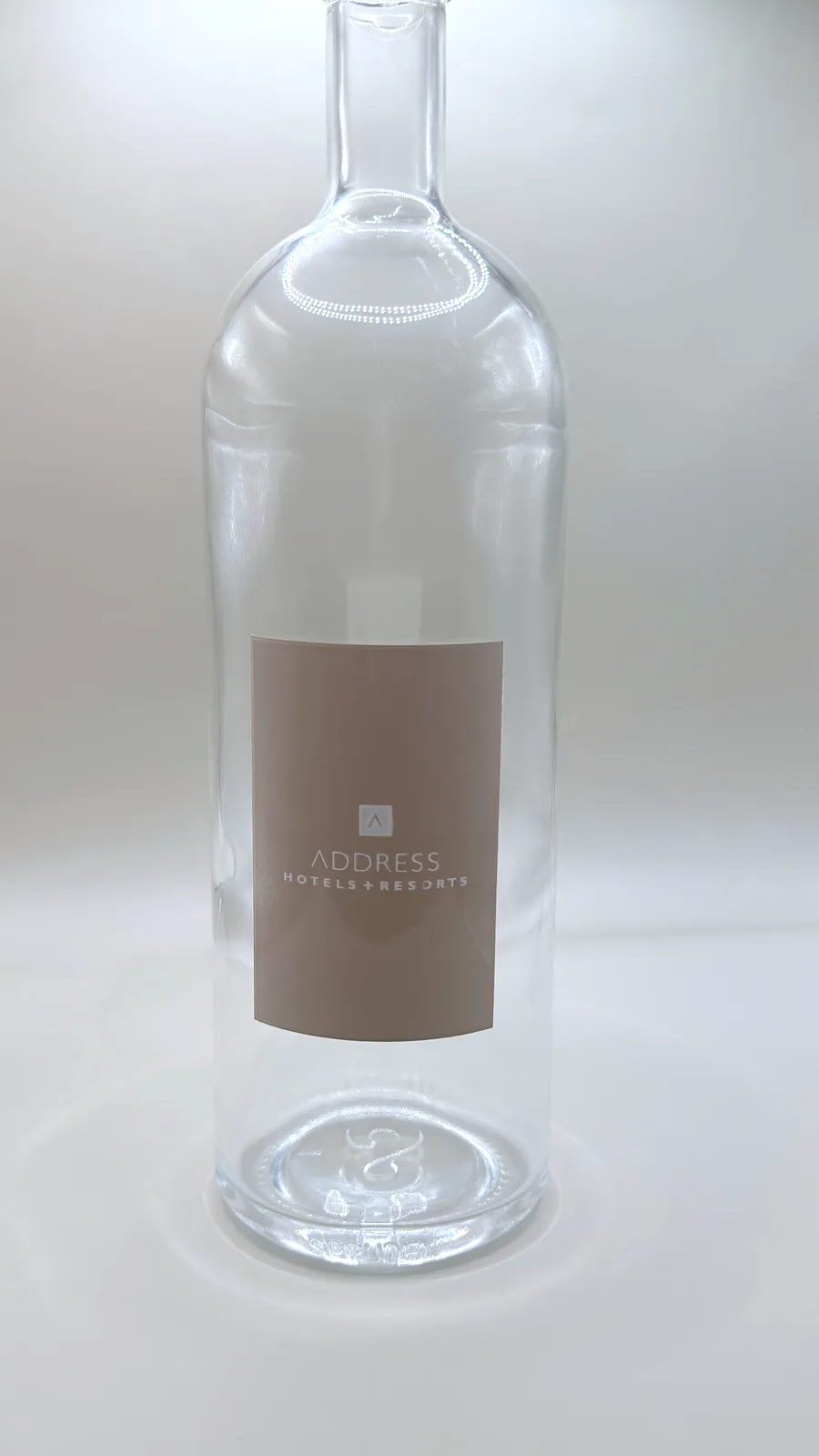 Sprudel glass water bottle with a taupe Address Hotels + Resorts label