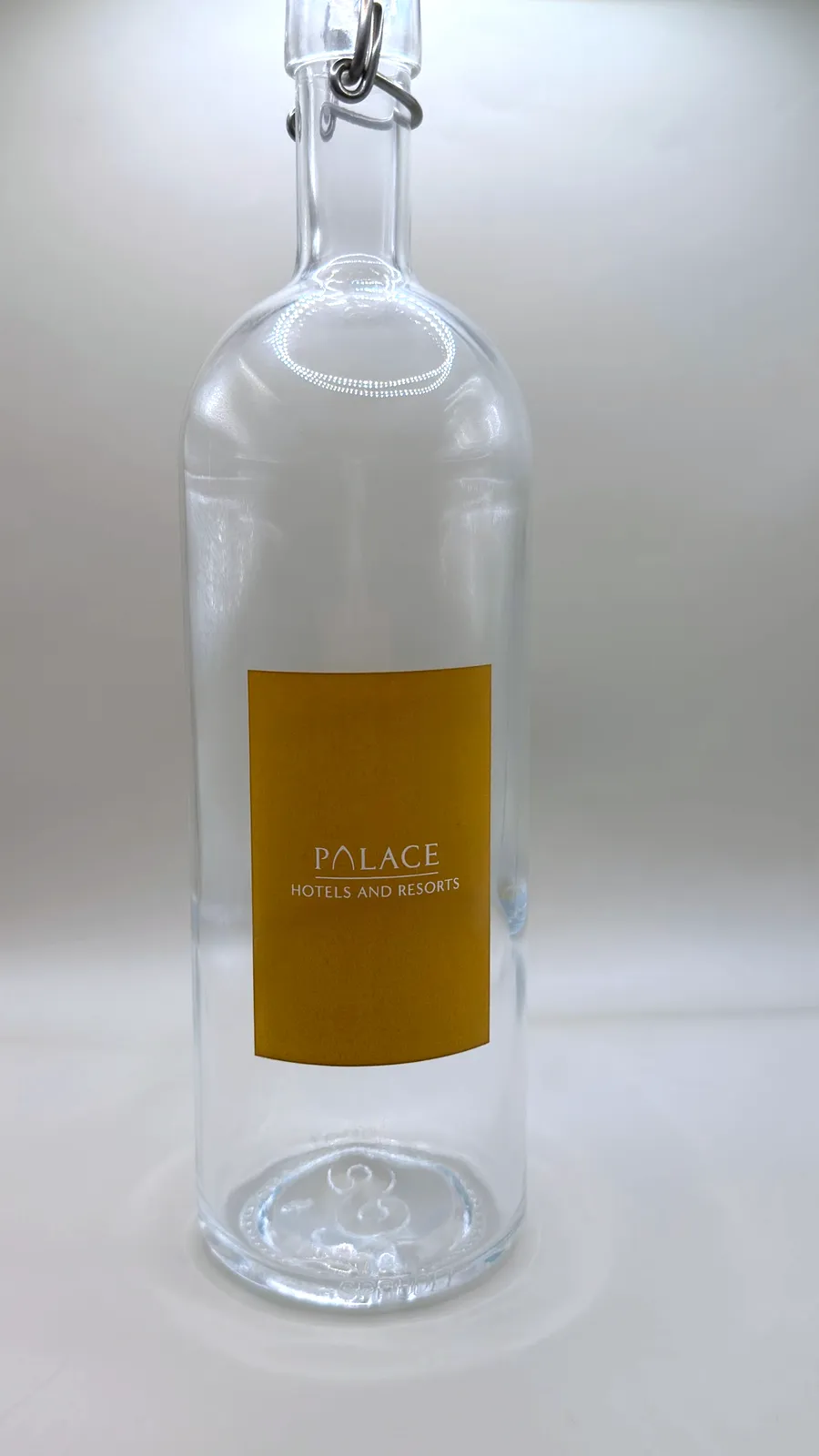 Sprudel swing-top glass water bottle with a gold Palace Hotels and Resorts label